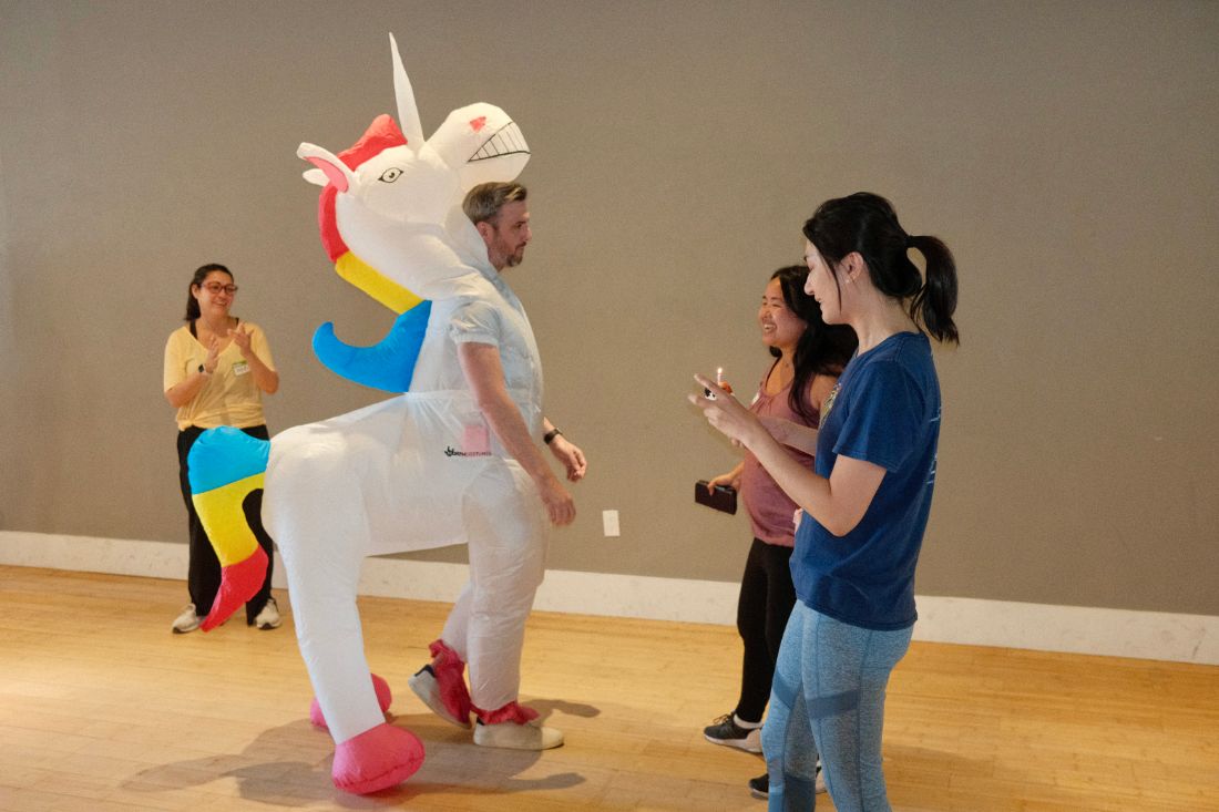 A participant in an inflatable unicorn costume