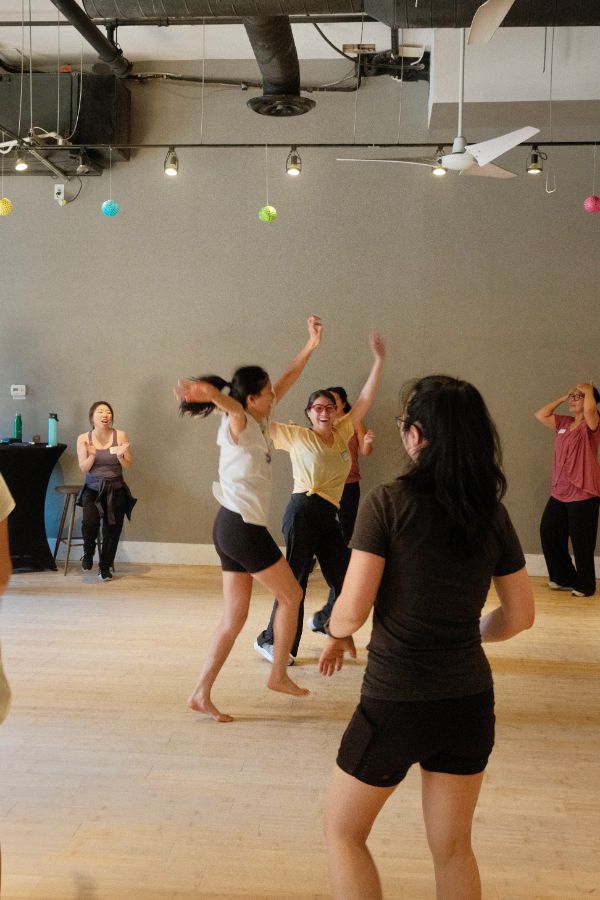 Participants dancing with arms overhead