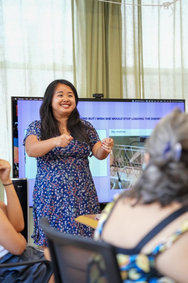 Erica speaking, mid-sentence, in front of a screen