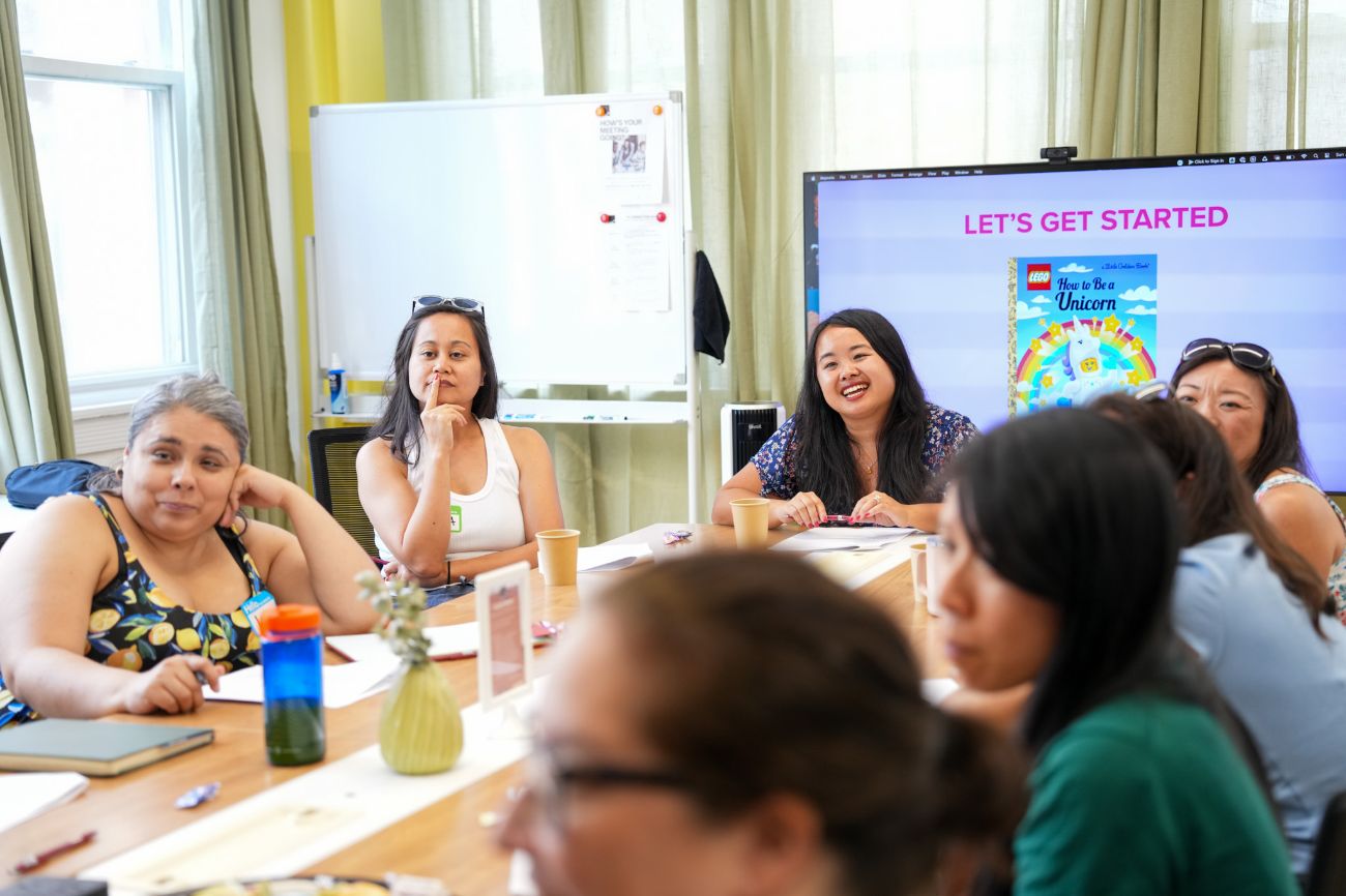 Participants writing and talking at a shared table