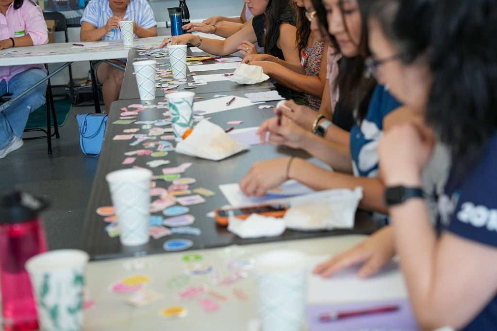 Tables covered in stickers, everyone mid-build